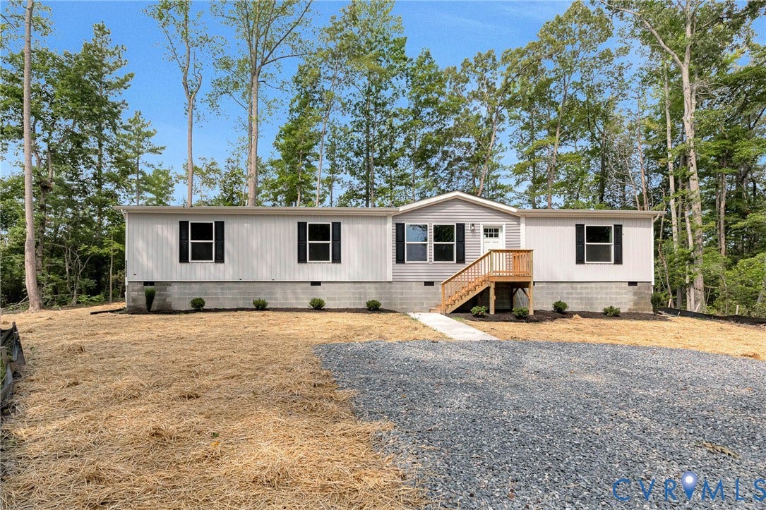 15263 Cross County Road, Mineral, VA 23117 White horizontal siding exterior with black shutters, light gray siding accent, natural wood exterior stairs, and a gravel driveway