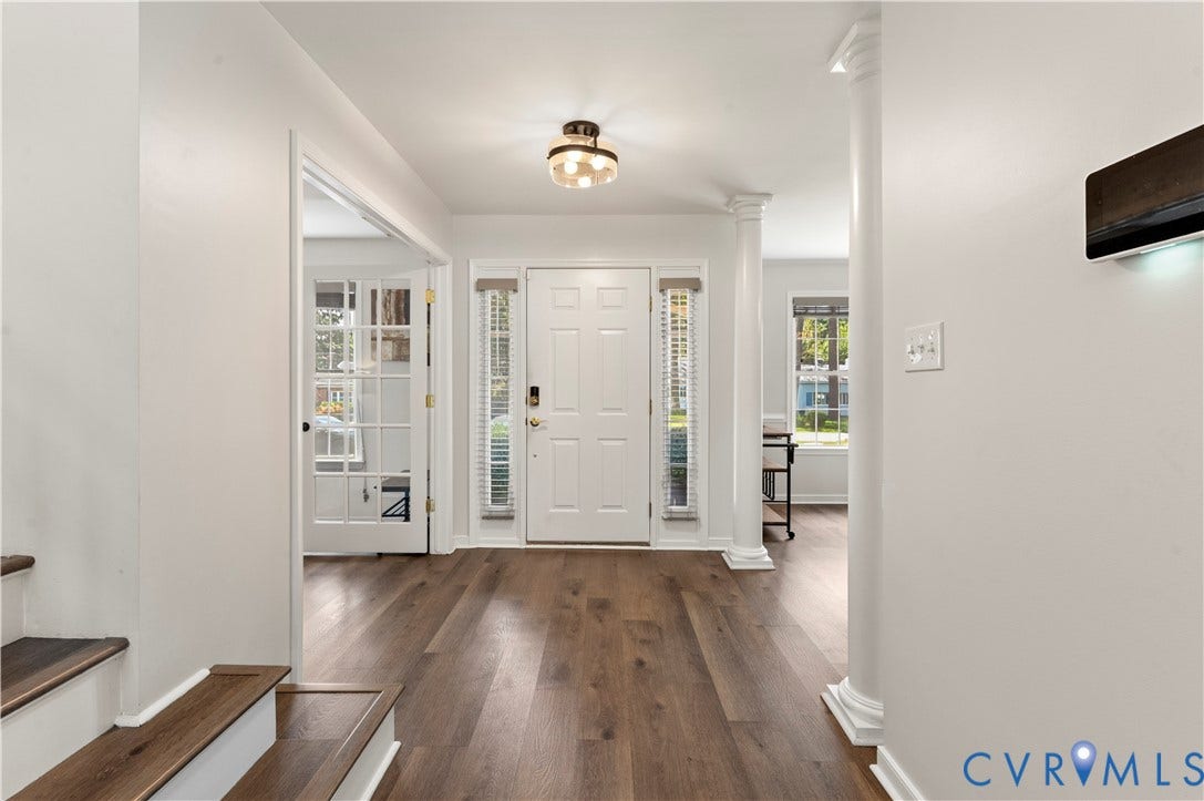 Bright open foyer with new light fixture, flooring and paint.