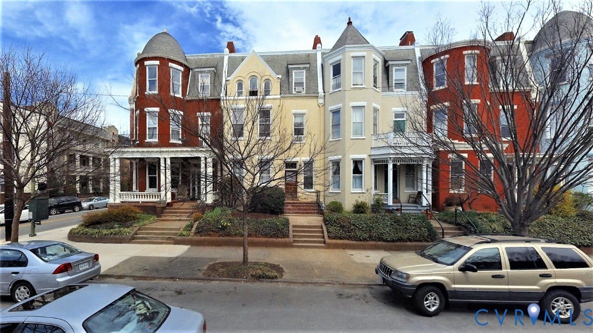 1524 Grove Avenue, Richmond, VA 23220 Brick exterior with a turret-style roof, covered front porch, and manicured landscaping