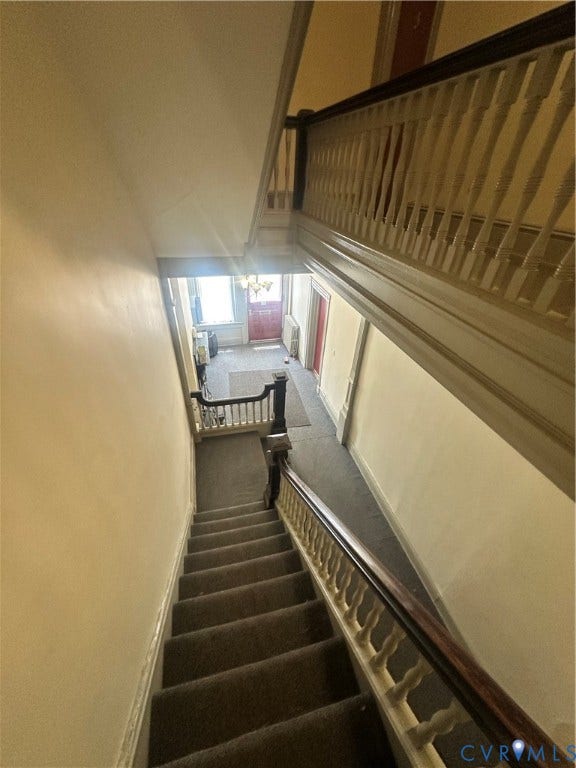 1524 Grove Avenue, Richmond, VA 23220 Staircase featuring dark wood handrail, white balusters, and carpeted treads