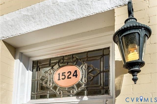 1524 Grove Avenue, Richmond, VA 23220 Ornate leaded glass transom with custom house numbers, featuring a dark-finish exterior wall lantern and light-colored brick exterior