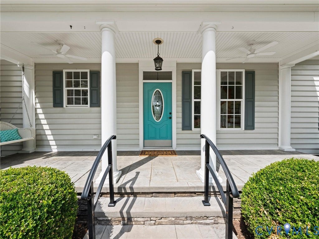 6126 Cartersville Road, Powhatan, VA 23139 Covered front porch with decorative columns, light-colored siding, and a vibrant turquoise entry door with oval glass