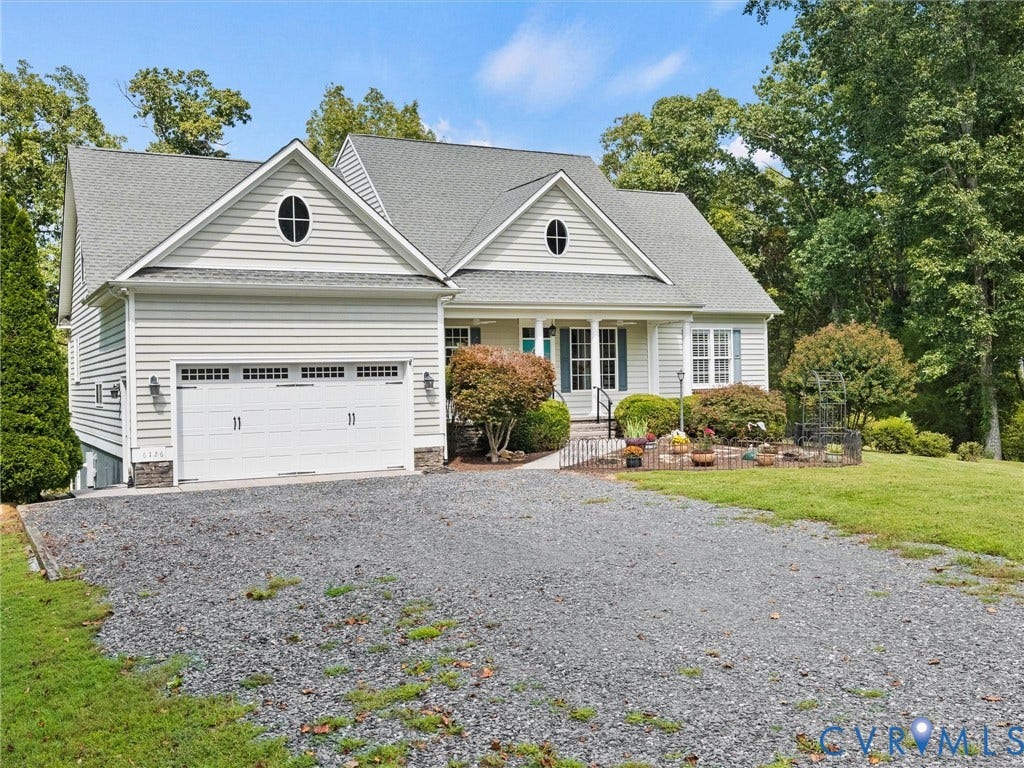 6126 Cartersville Road, Powhatan, VA 23139 White siding exterior with a multi-gable roofline, attached garage, and a gravel driveway