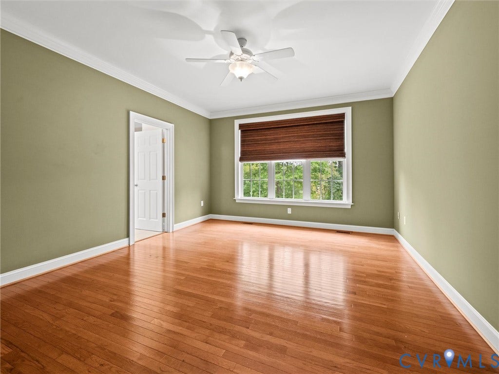 6126 Cartersville Road, Powhatan, VA 23139 Hardwood flooring, crown molding, ceiling fan with light fixture, window with slatted blind, and white trim throughout
