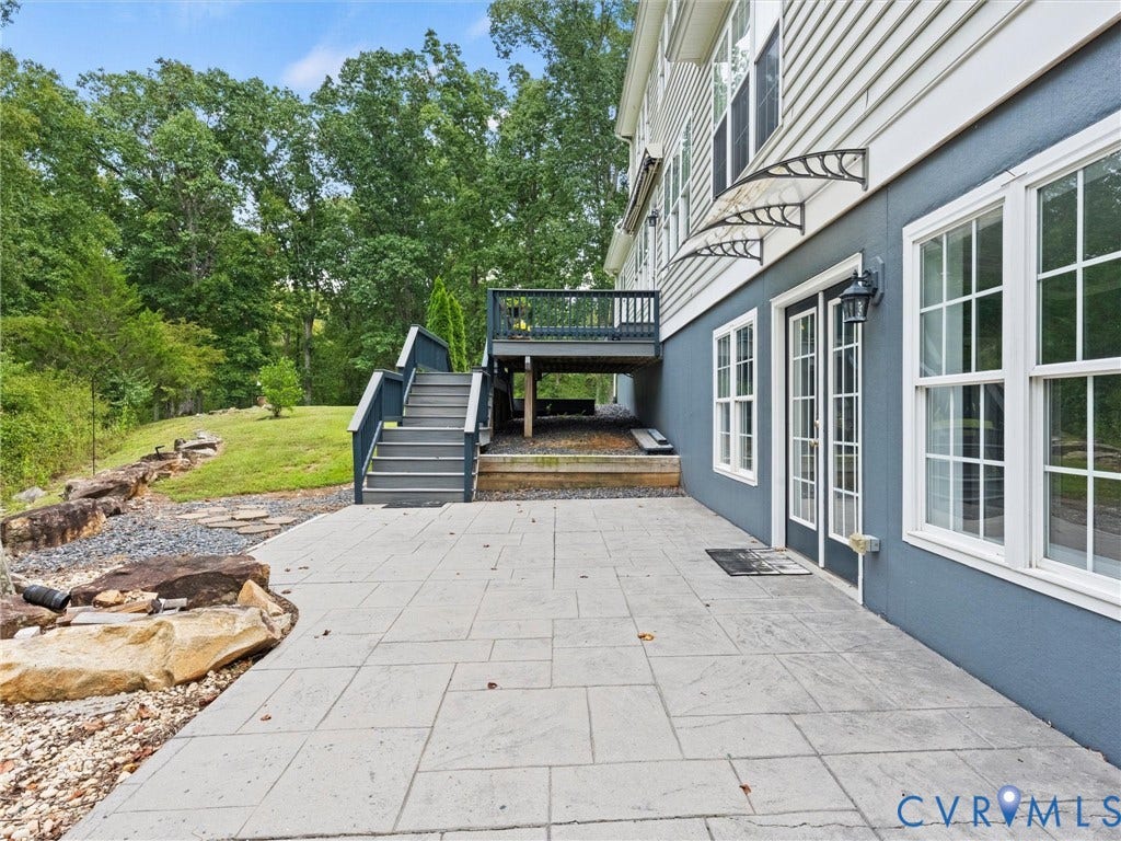 6126 Cartersville Road, Powhatan, VA 23139 Rear patio featuring stone pavers and a natural rock retaining wall