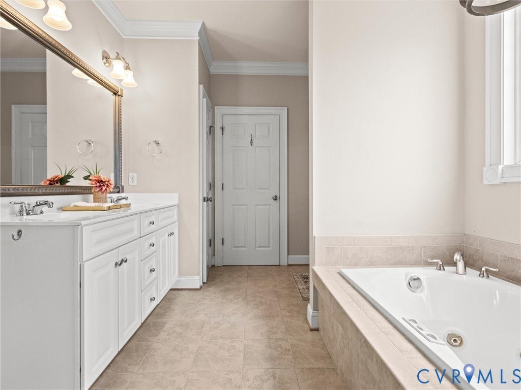 6126 Cartersville Road, Powhatan, VA 23139 Dual vanity with white cabinetry, polished chrome hardware, and a framed mirror