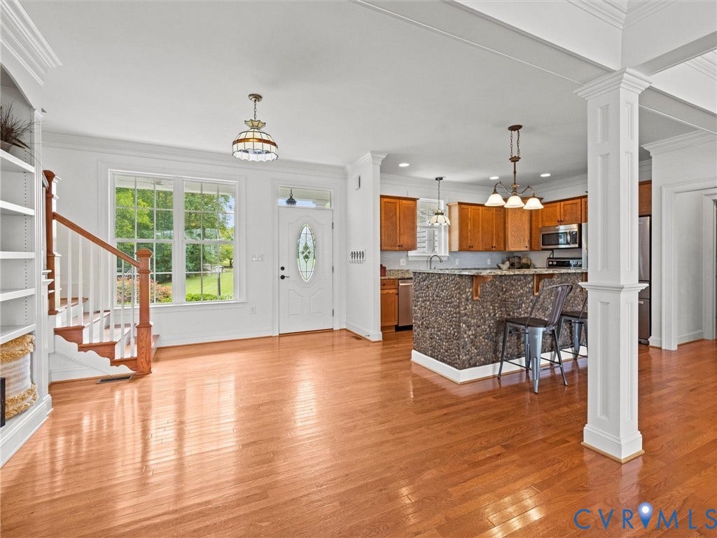 6126 Cartersville Road, Powhatan, VA 23139 Hardwood flooring extends throughout this open-concept space, featuring a kitchen with wood cabinetry and stone-clad breakfast bar