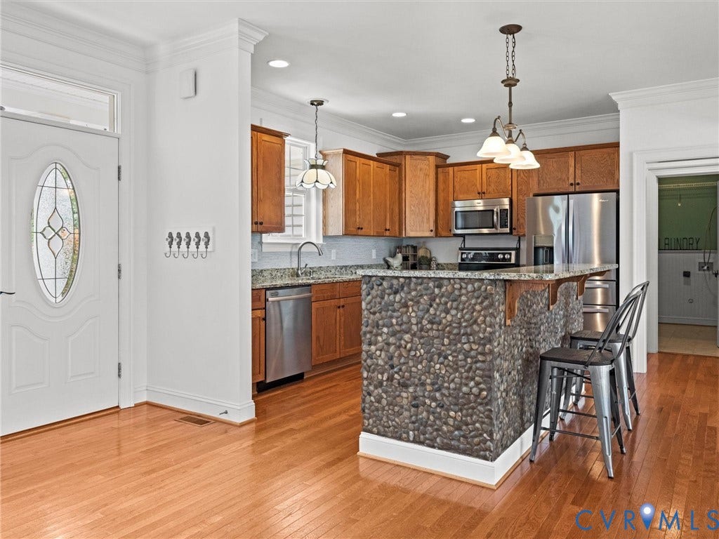 6126 Cartersville Road, Powhatan, VA 23139 Hardwood flooring, custom stone-finish breakfast bar, integrated stainless steel appliances, solid surface countertops, and wood-finish cabinetry