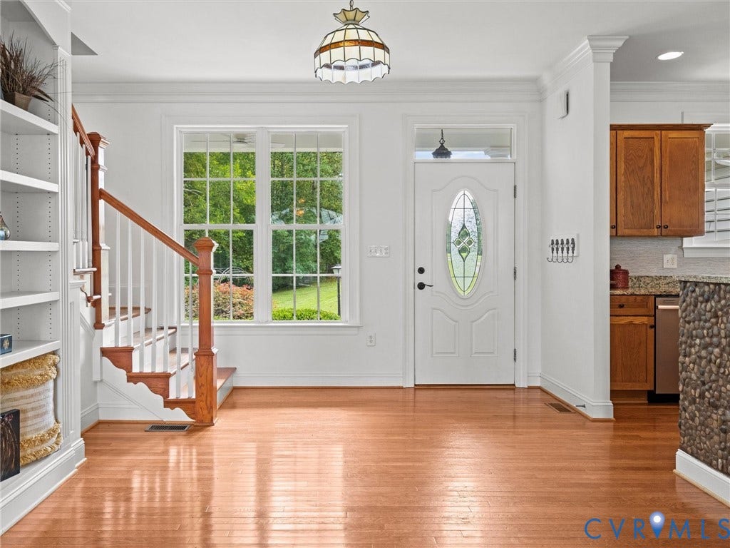 6126 Cartersville Road, Powhatan, VA 23139 Hardwood flooring, white painted walls, natural wood staircase, built-in shelving, and a decorative glass front door