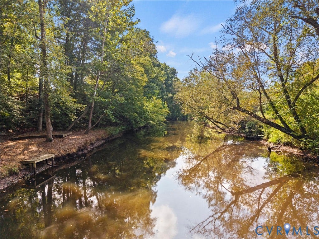 6126 Cartersville Road, Powhatan, VA 23139 Waterfront property featuring a wooded bank with mature trees and a wooden dock