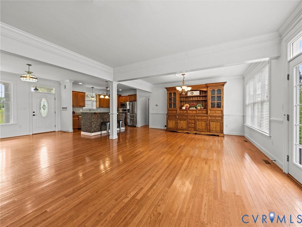 6126 Cartersville Road, Powhatan, VA 23139 Expansive open-concept room featuring wood-finish flooring, white crown molding, and a bay window with blinds