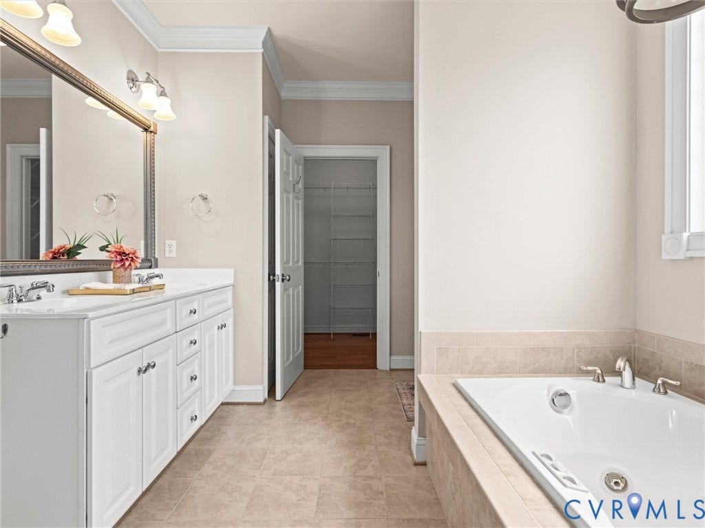 6126 Cartersville Road, Powhatan, VA 23139 Dual vanity with white cabinetry, built-in soaking tub, and tile flooring