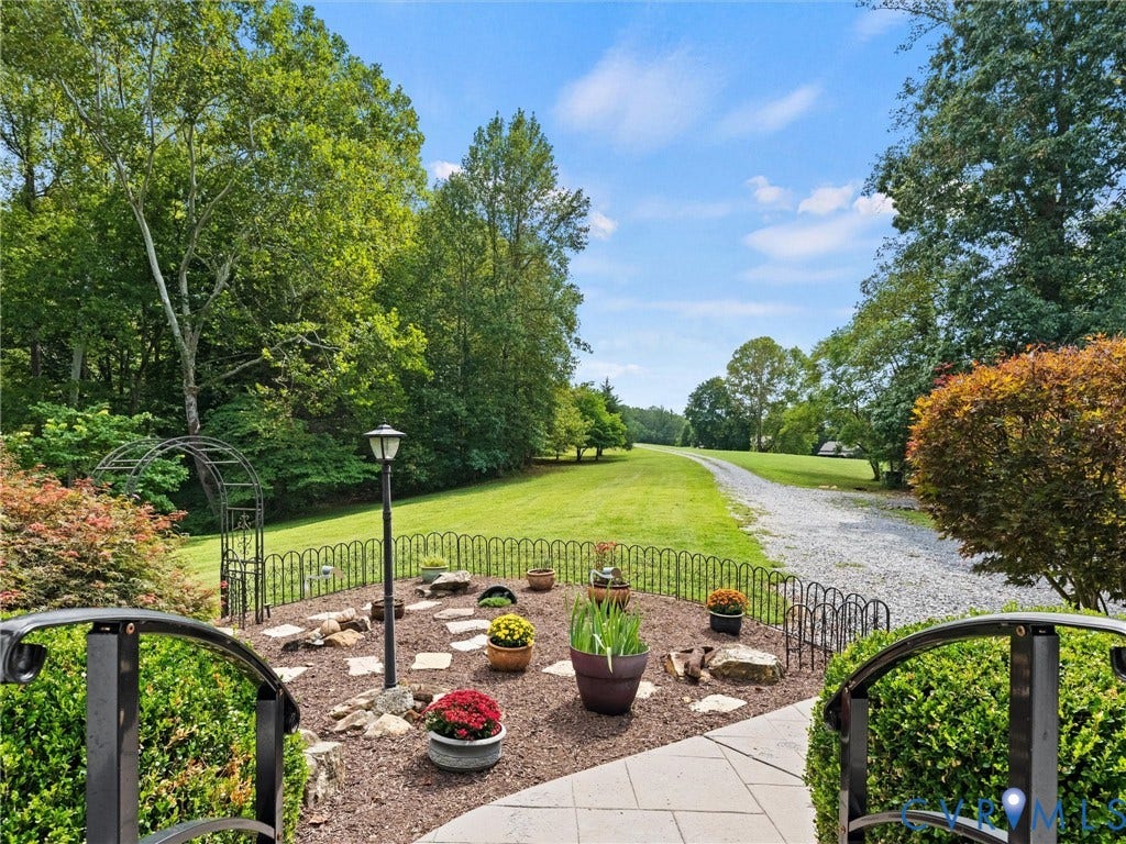 6126 Cartersville Road, Powhatan, VA 23139 Expansive gravel drive, mature trees, manicured lawn, and decorative garden arch