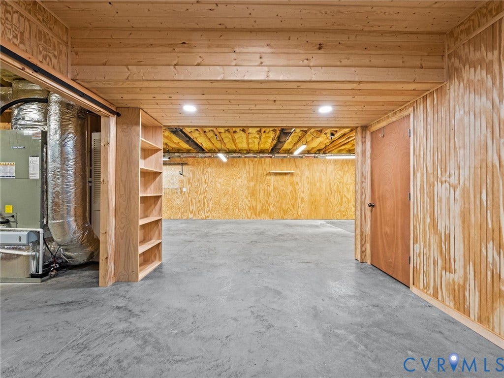 6126 Cartersville Road, Powhatan, VA 23139 Unfinished basement space featuring wood-paneled walls, exposed wood ceiling beams, recessed lighting, and a built-in shelving unit