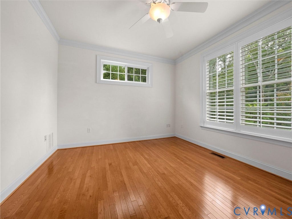 6126 Cartersville Road, Powhatan, VA 23139 Hardwood flooring, white walls, crown molding, two windows with plantation shutters, and a ceiling fan with integrated lighting
