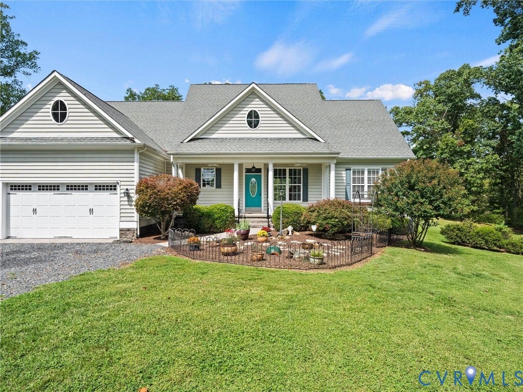 6126 Cartersville Road, Powhatan, VA 23139 Light-colored siding exterior with a partial stone facade, attached garage, covered front porch, and oval accent windows