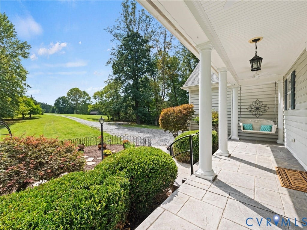 6126 Cartersville Road, Powhatan, VA 23139 Expansive front porch with column supports, overhead lantern lighting, horizontal siding, and stone-look tile flooring
