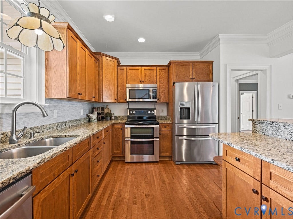 6126 Cartersville Road, Powhatan, VA 23139 Full kitchen featuring wood-finish cabinetry, granite countertops, stainless steel appliances, and wood-finish flooring
