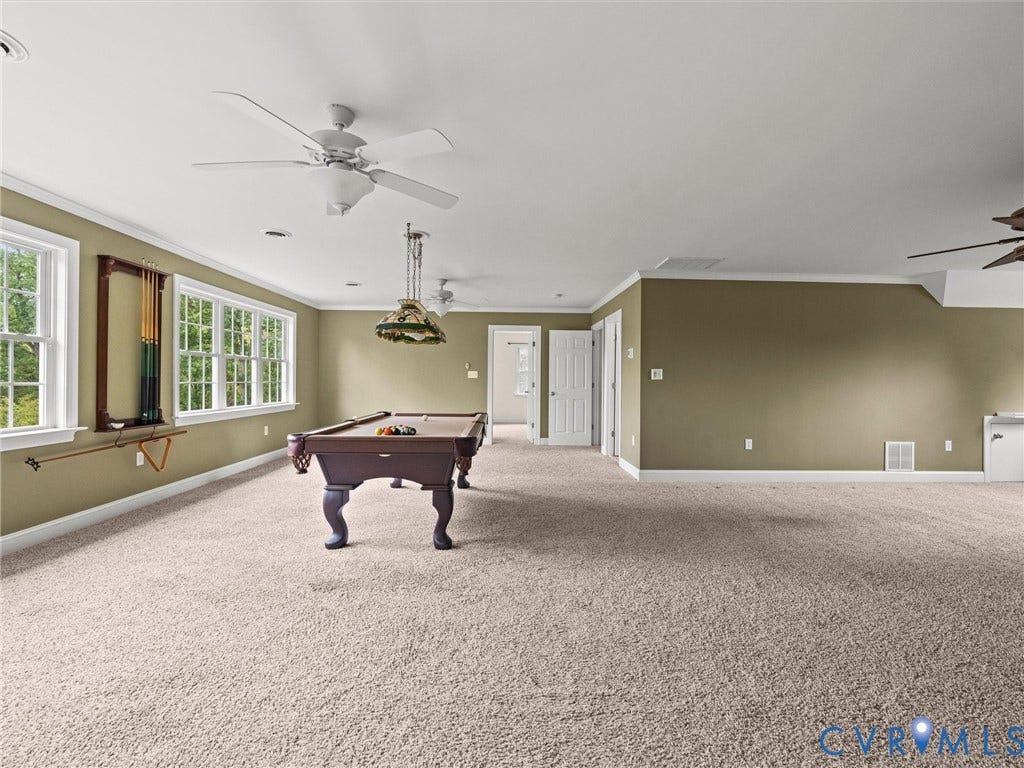 6126 Cartersville Road, Powhatan, VA 23139 Expansive carpeted room featuring multiple windows, crown molding, and ceiling fans