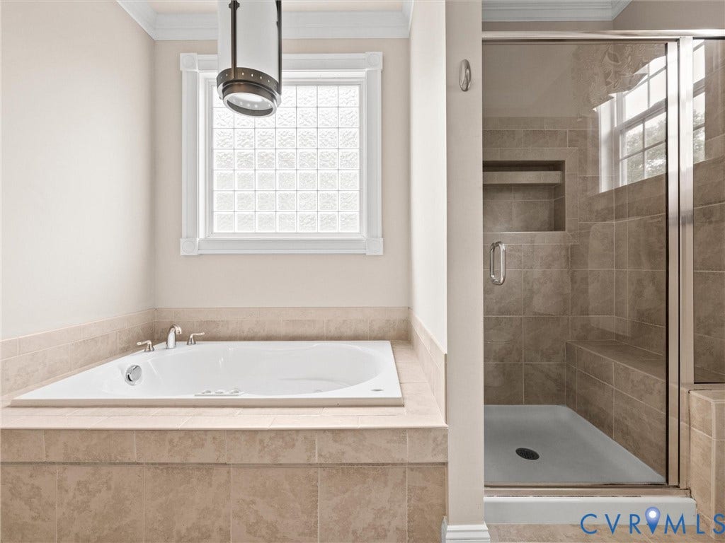6126 Cartersville Road, Powhatan, VA 23139 Soaking tub with tile surround, glass block window, walk-in shower with tiled walls, built-in shower bench, and recessed shower niche