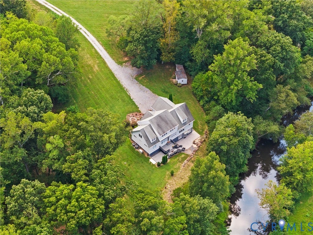 6126 Cartersville Road, Powhatan, VA 23139 Expansive property with a gravel driveway, mature trees, and a bordering waterway