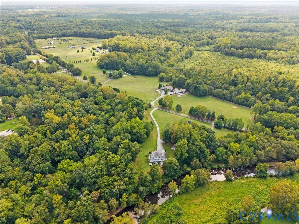 6126 Cartersville Road, Powhatan, VA 23139 Expansive wooded acreage featuring a meandering stream, open fields, and scattered residential structures