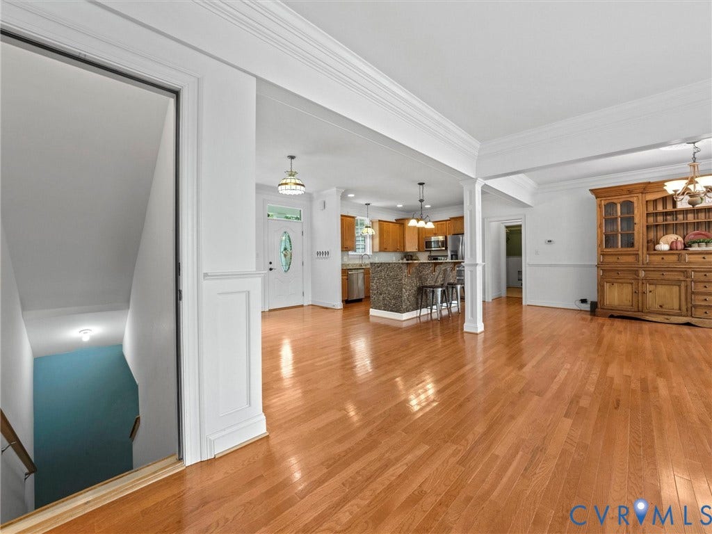 6126 Cartersville Road, Powhatan, VA 23139 Hardwood flooring throughout, crown molding details, white trim accents, and a kitchen featuring a stone-clad island