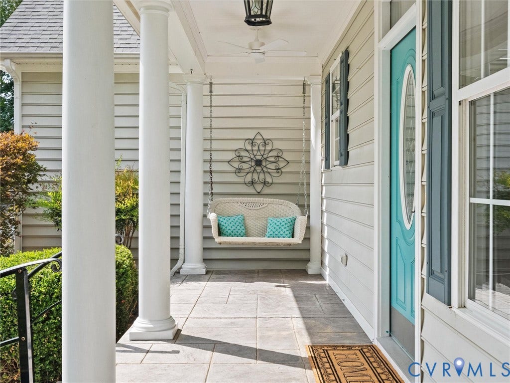 6126 Cartersville Road, Powhatan, VA 23139 Covered front porch with square tile flooring, white support columns, gray siding, and a turquoise entry door with decorative glass