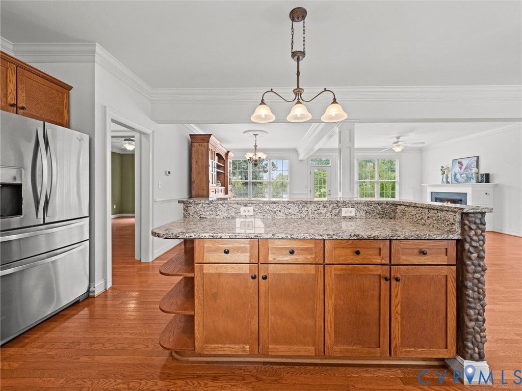 6126 Cartersville Road, Powhatan, VA 23139 Kitchen island with a granite countertop, wood cabinetry, and a stone-clad end panel