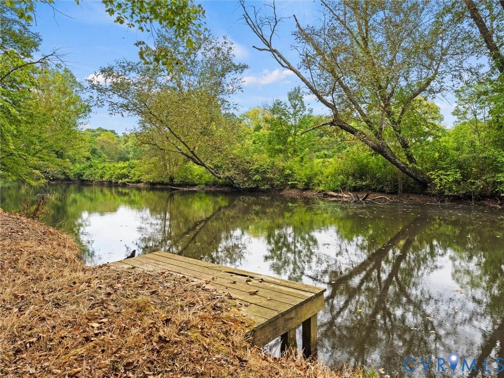 6126 Cartersville Road, Powhatan, VA 23139 Waterfront property featuring a wooden dock, mature trees, and natural landscaping
