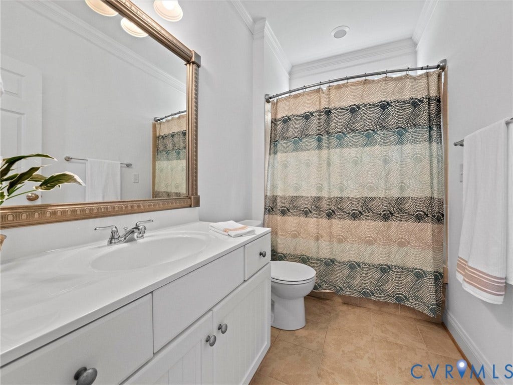 6126 Cartersville Road, Powhatan, VA 23139 White vanity with integrated sink, chrome faucet, and bronze-framed mirror