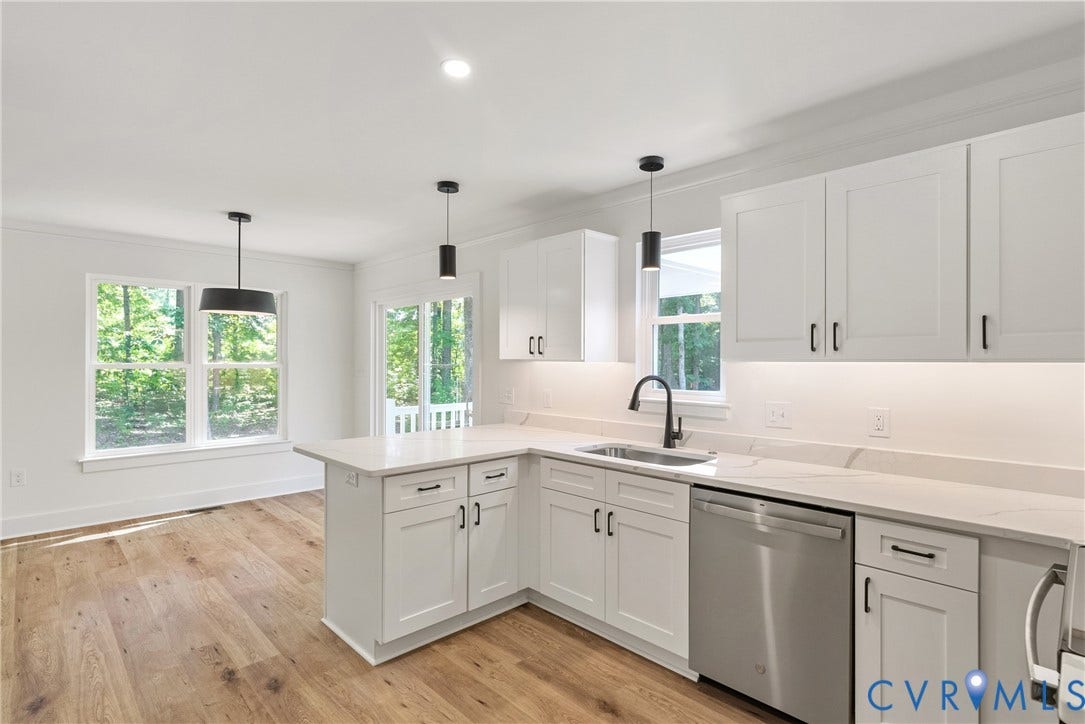 6465 Anderson Highway, Powhatan, VA 23139 White shaker cabinetry, light-toned countertops, wood-finish flooring, stainless steel appliances, and matte black hardware