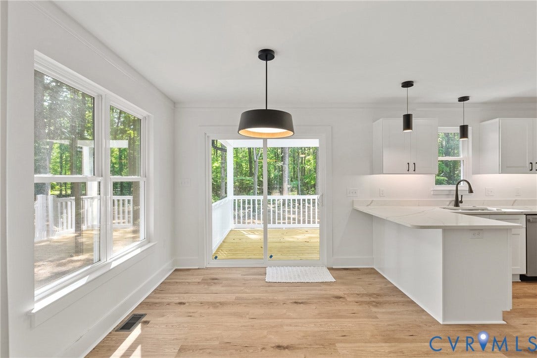 6465 Anderson Highway, Powhatan, VA 23139 Wood-finish flooring, built-in shelving, large window, sliding glass door, and drum pendant light fixture