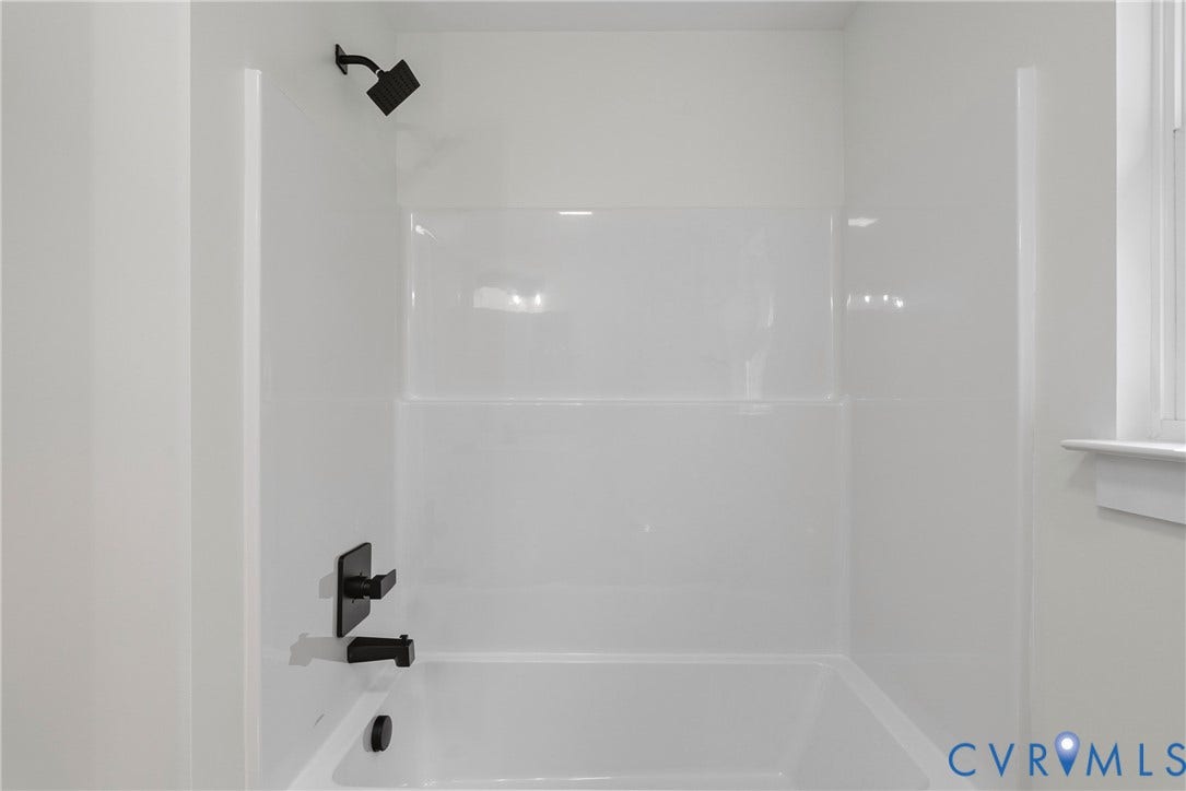 6465 Anderson Highway, Powhatan, VA 23139 Bathtub with integrated shower surround, featuring matte black fixtures and a window