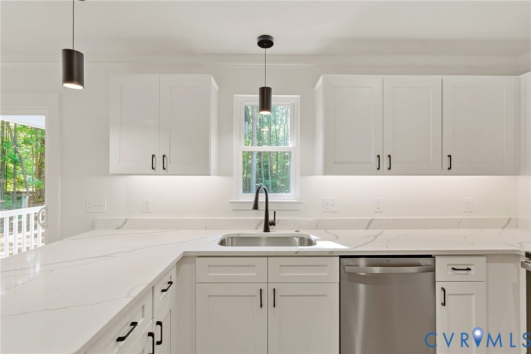 6465 Anderson Highway, Powhatan, VA 23139 White shaker cabinetry with black hardware, an undermount stainless steel sink, a stainless steel dishwasher, and a white countertop with subtle veining