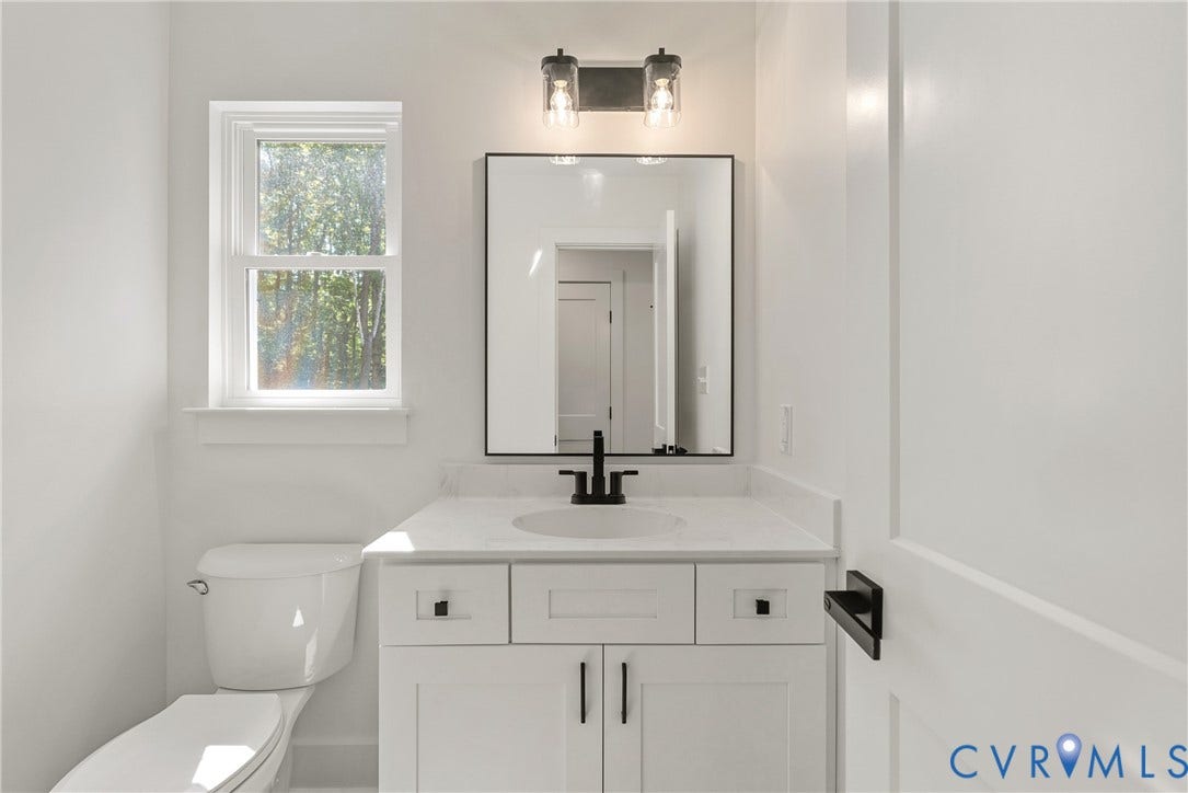 6465 Anderson Highway, Powhatan, VA 23139 White vanity with matte black hardware, single sink, and a rectangular mirror