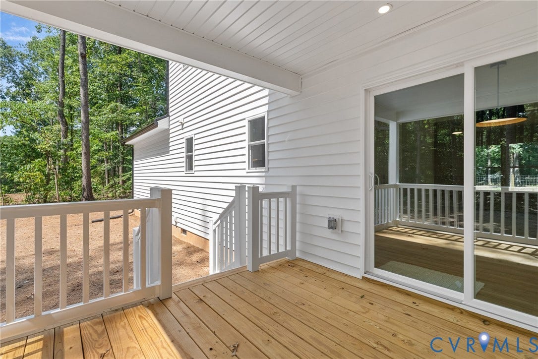 6465 Anderson Highway, Powhatan, VA 23139 Expansive wood-finish deck with white railings, offering access to a screened porch through a sliding glass door