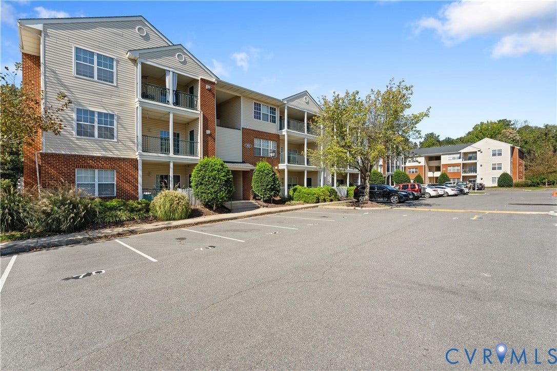821 Brassie Lane, #E, The Crossings Golf Course Area, Glen Allen, VA 23059 Exterior facade featuring brick masonry, horizontal siding, private balconies, and asphalt-paved parking