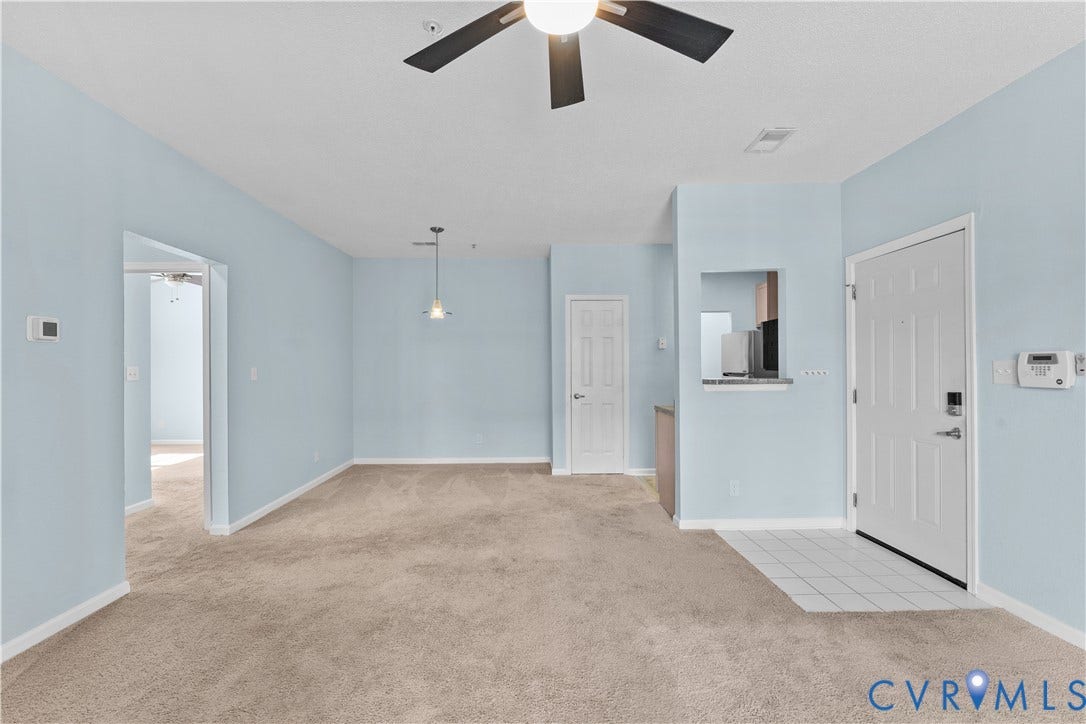 821 Brassie Lane, #E, The Crossings Golf Course Area, Glen Allen, VA 23059 Open interior space featuring a ceiling fan, carpeted flooring, tile entryway, pendant lighting, and a passthrough window
