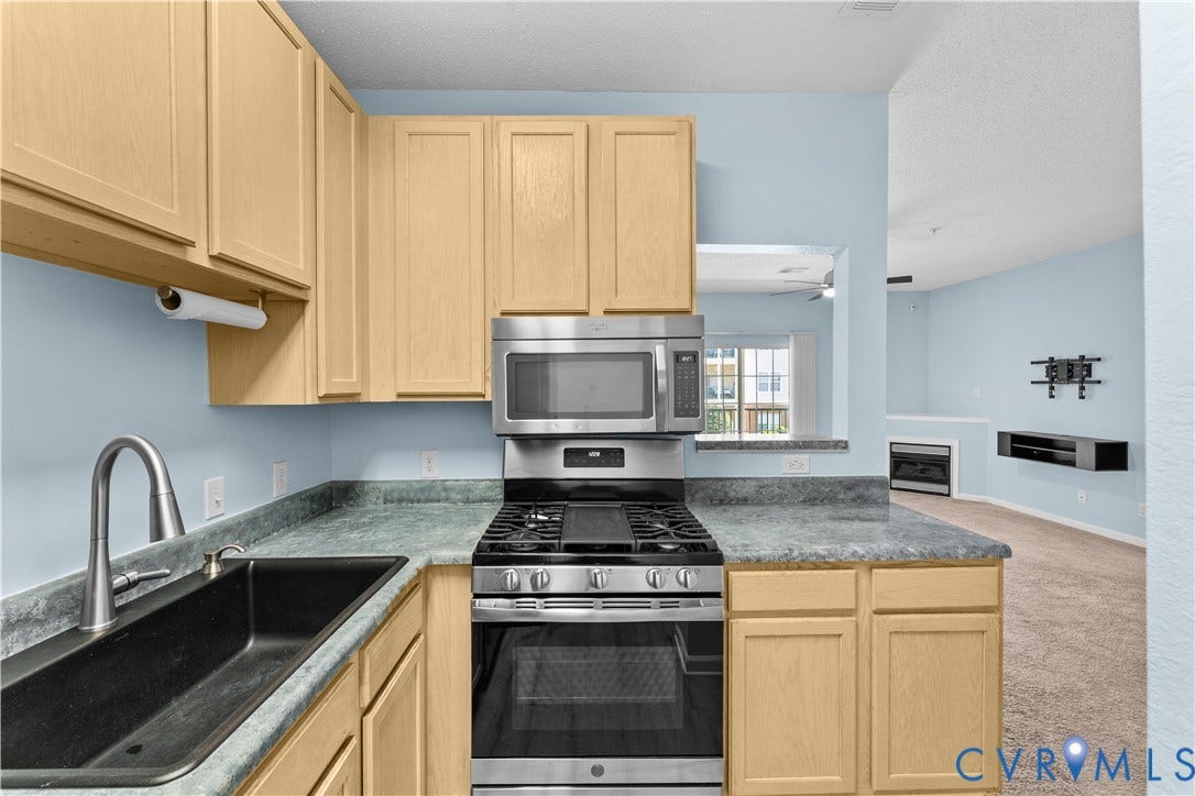 821 Brassie Lane, #E, The Crossings Golf Course Area, Glen Allen, VA 23059 Kitchen featuring light-finish cabinetry, stone-texture laminate countertops, a black undermount sink with a high-arch faucet, and stainless steel gas range with a built-in microwave