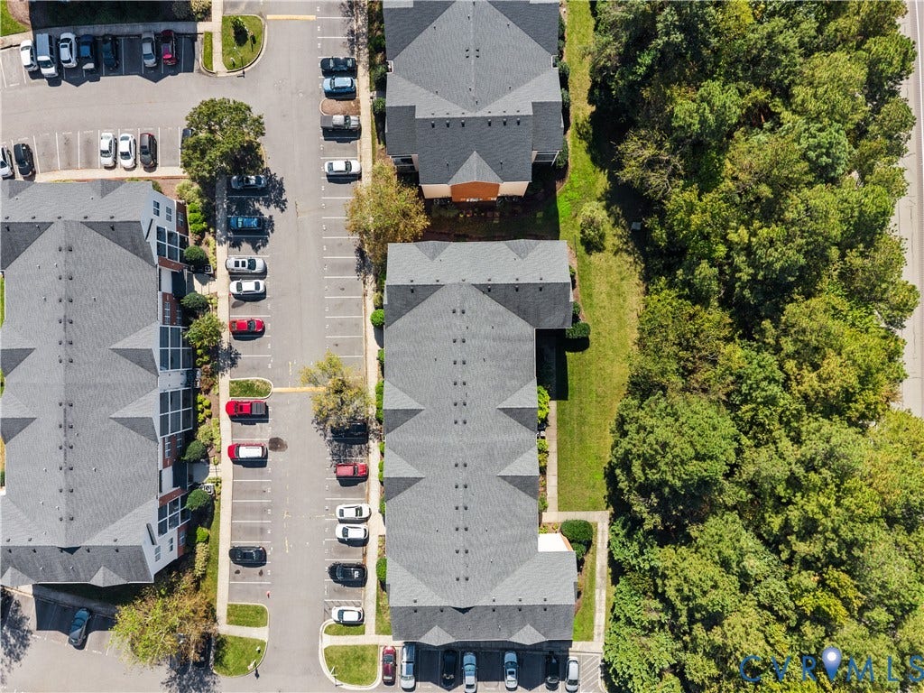 821 Brassie Lane, #E, The Crossings Golf Course Area, Glen Allen, VA 23059 Aerial perspective of multi-building complex featuring asphalt parking surfaces, shingled roofing systems, and dense wooded borders