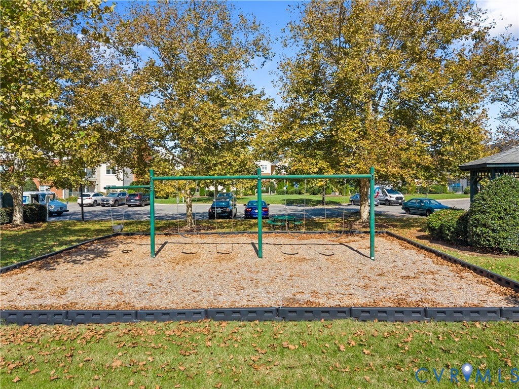 821 Brassie Lane, #E, The Crossings Golf Course Area, Glen Allen, VA 23059 Outdoor recreation area featuring a metal swing set, wood-chip surface, and mature perimeter trees