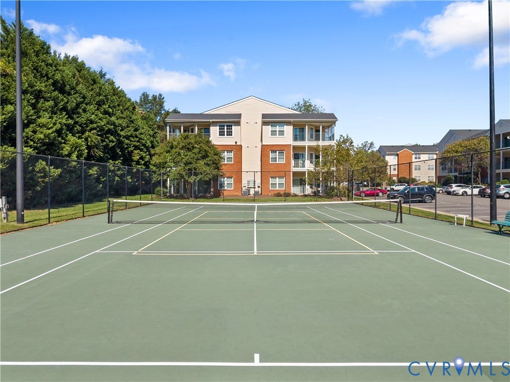 821 Brassie Lane, #E, The Crossings Golf Course Area, Glen Allen, VA 23059 Tennis court featuring a paved surface, perimeter chain-link fencing, and stadium-style lighting poles