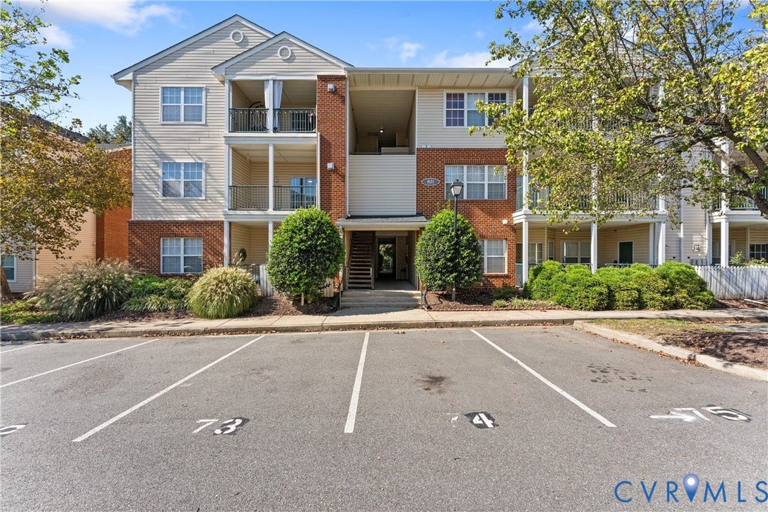 821 Brassie Lane, #E, The Crossings Golf Course Area, Glen Allen, VA 23059 Multi-story building exterior featuring vinyl siding, brick masonry, private balconies, and assigned asphalt parking