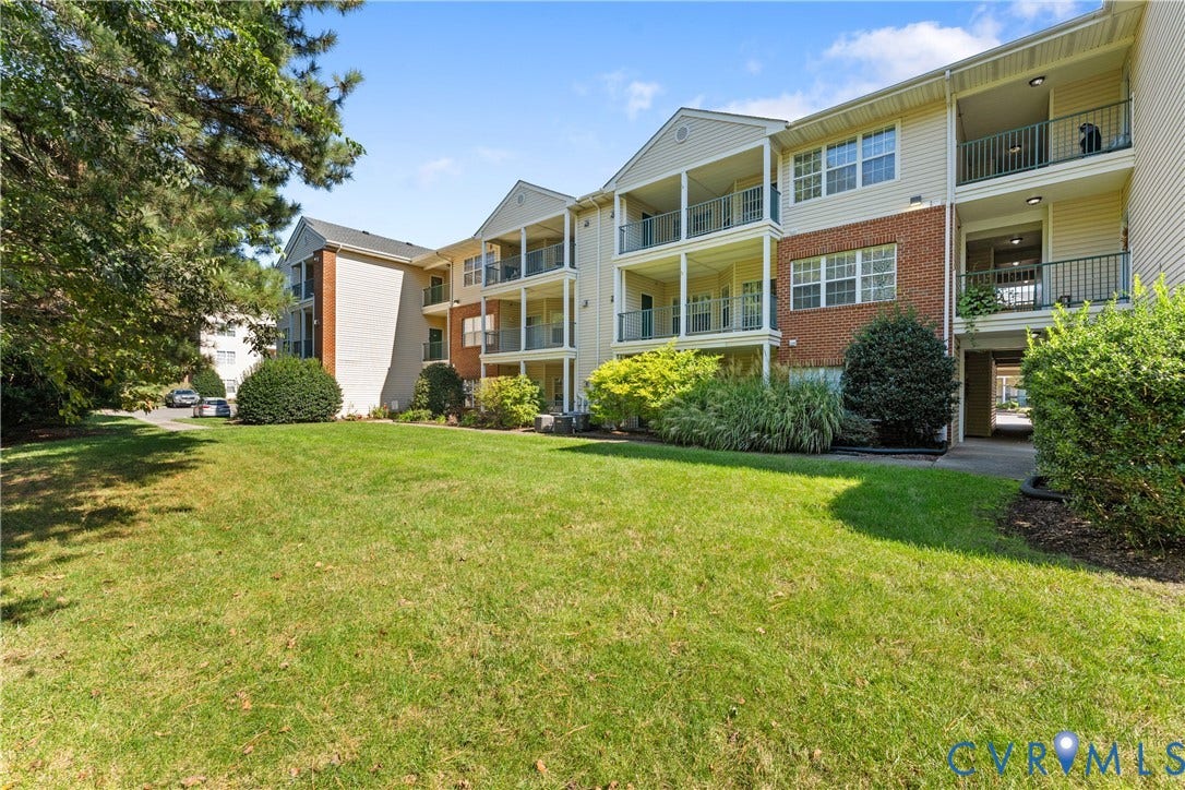 821 Brassie Lane, #E, The Crossings Golf Course Area, Glen Allen, VA 23059 Exterior featuring brick and siding facade, covered balconies, and landscaped grounds