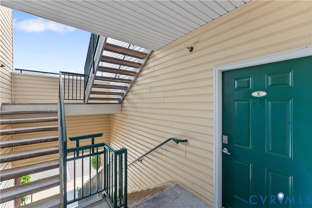 821 Brassie Lane, #E, The Crossings Golf Course Area, Glen Allen, VA 23059 Exterior entryway featuring horizontal siding, a solid panel door with metallic hardware, and an open-air metal staircase with railing