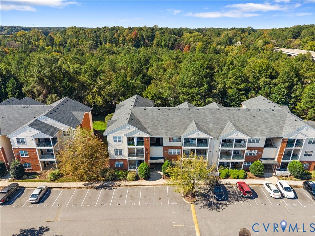 821 Brassie Lane, #E, The Crossings Golf Course Area, Glen Allen, VA 23059 Multi-story complex featuring brick and siding facade, gabled rooflines, covered balconies, and dedicated asphalt parking