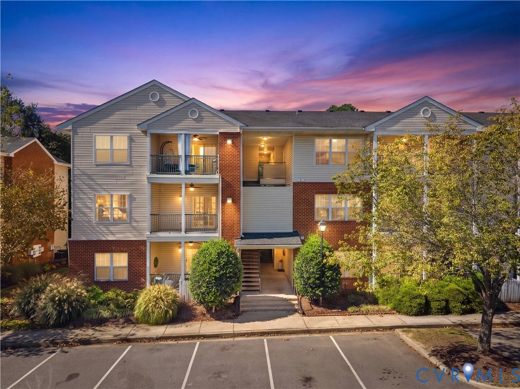821 Brassie Lane, #E, The Crossings Golf Course Area, Glen Allen, VA 23059 Multi-story residential building featuring brick and horizontal siding exterior, private covered balconies, and paved surface parking