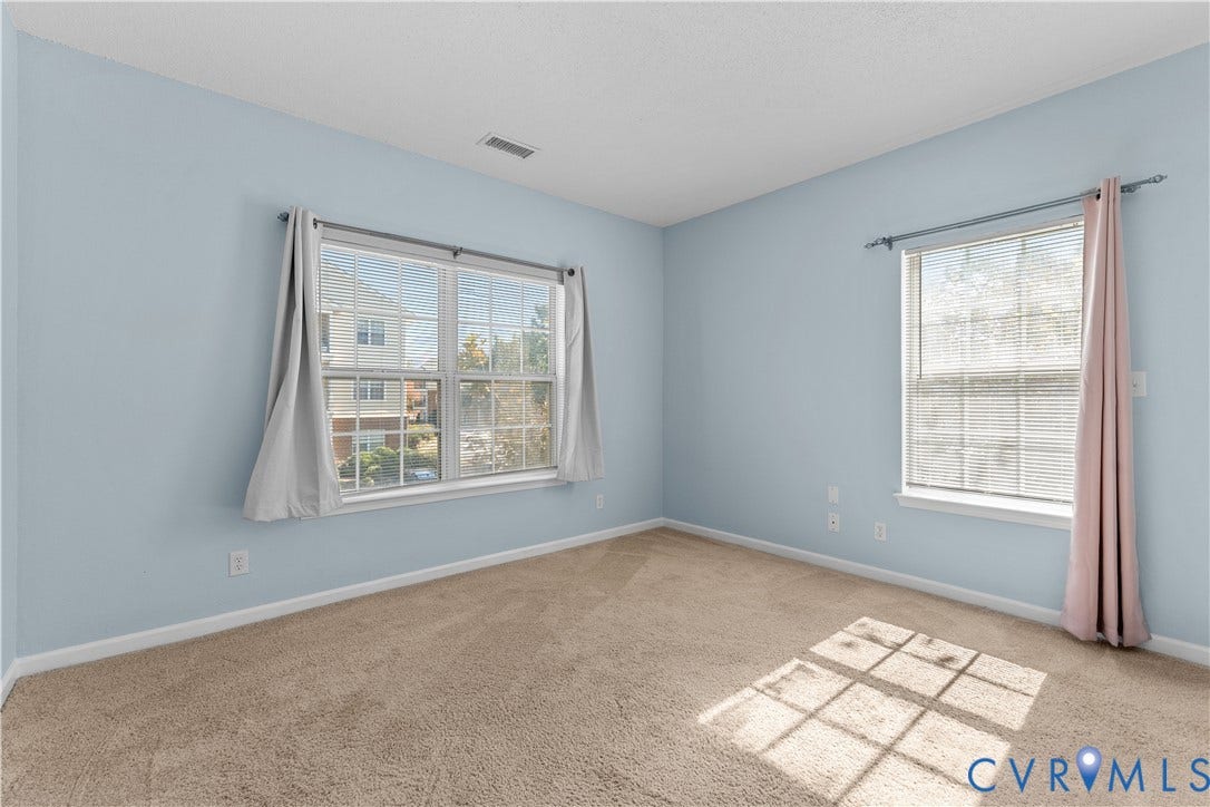 821 Brassie Lane, #E, The Crossings Golf Course Area, Glen Allen, VA 23059 Interior room featuring neutral-toned carpeting, two windows with grid-patterned muntins, and ample natural light