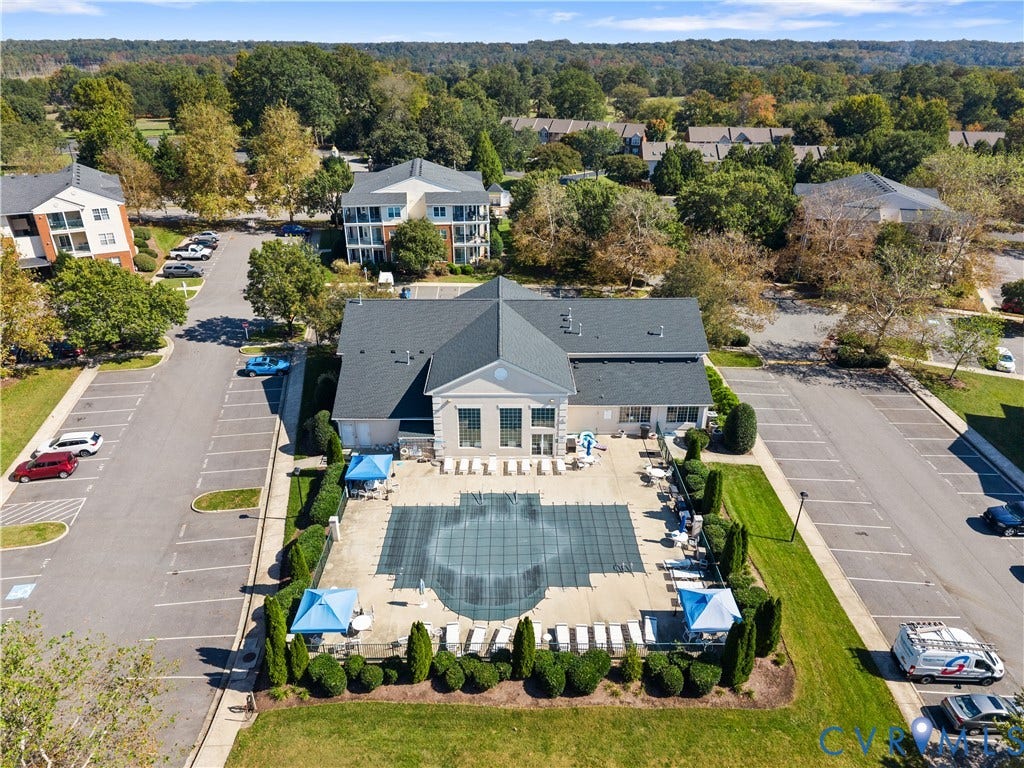 821 Brassie Lane, #E, The Crossings Golf Course Area, Glen Allen, VA 23059 Community clubhouse featuring a shingled roof, exterior patio, and gated swimming pool with surrounding landscaping and dedicated parking